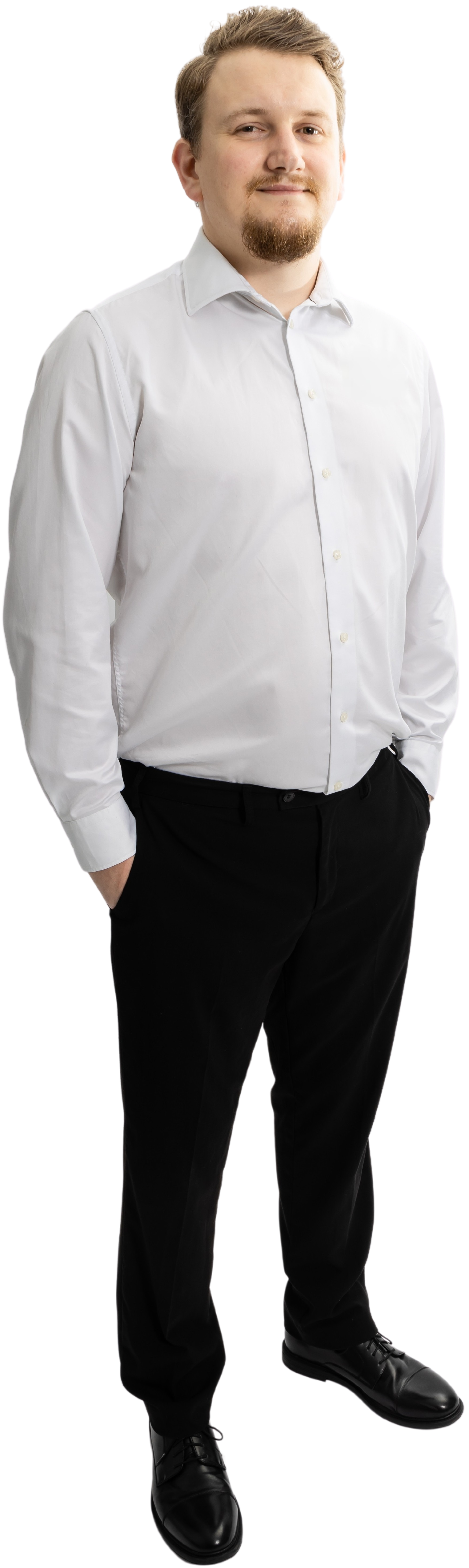 Graeme Lambert in a white shirt and black pants standing with his hands in his pockets